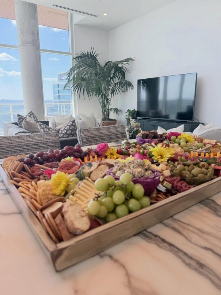 3-foot charcuterie board on a marble island with a window and city view