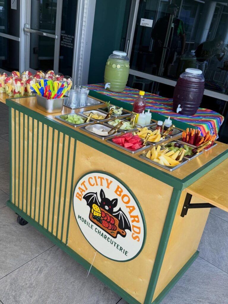 Mobile cart set up for a Mexican fruit cup event with agua fresca dispensers