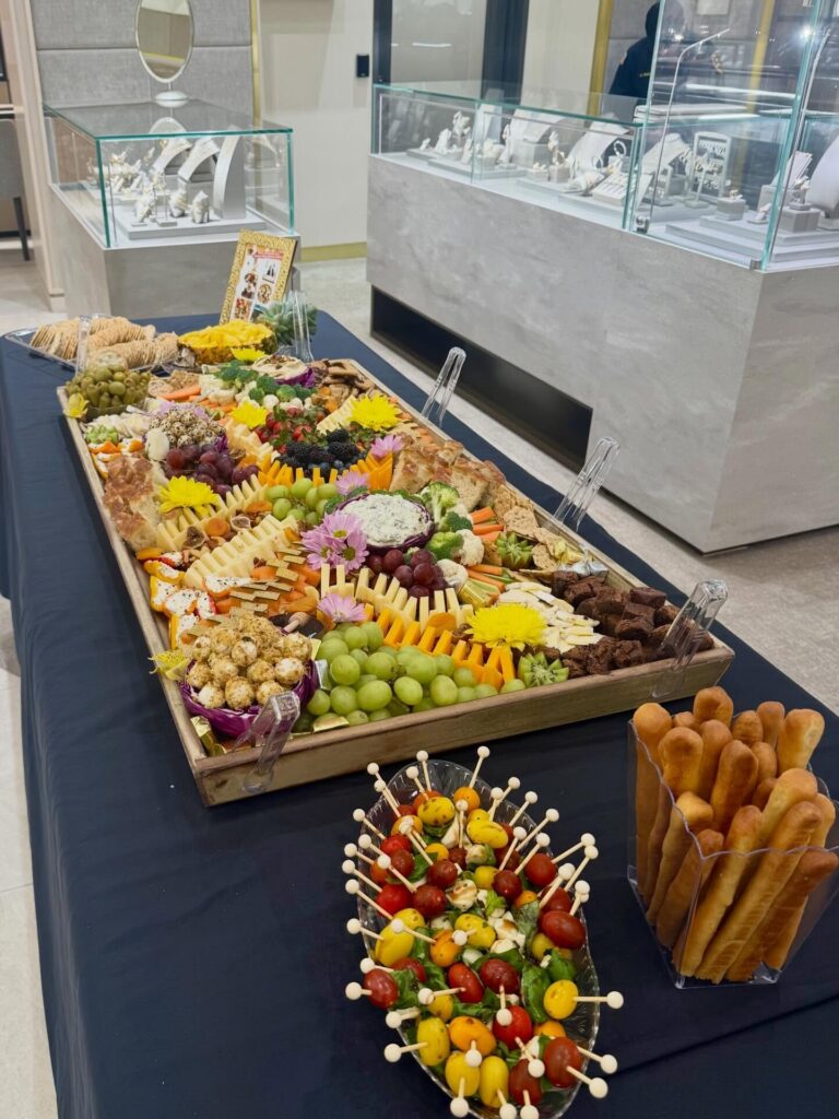 Long grazing table in a jewelry showroom (Zadok Jewelers) with fruit skewers