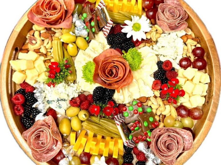 Round board with three salami roses, daisy, cheeses and berries
