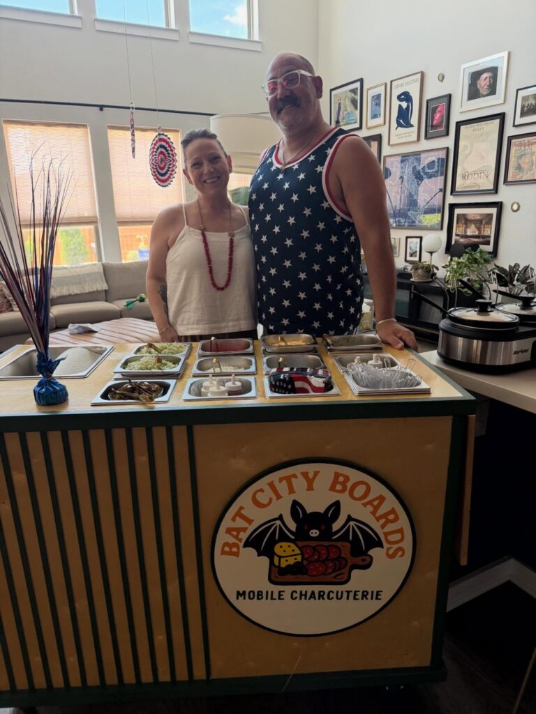 Brie and Corey with the Bat City Boards cart set up as a walking taco bar at a home party